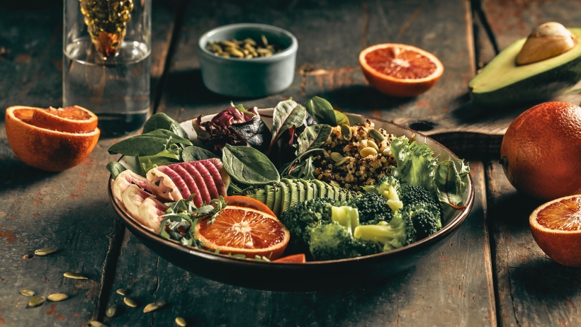 Eine Schüssel mit verschiedenen frischen Gemüsesorten steht auf einem rustikalen Holztisch. Perfekt für Anfänger, die vegane Rezepte ausprobieren möchten.